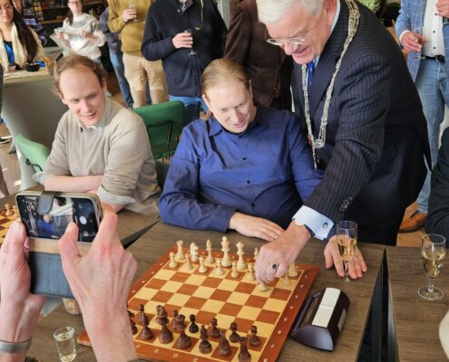 Burgemeester Jan van Zanen verricht de openingszet tijdens het 100-jarig jubileum van de Haagse Schaak Vereniging
