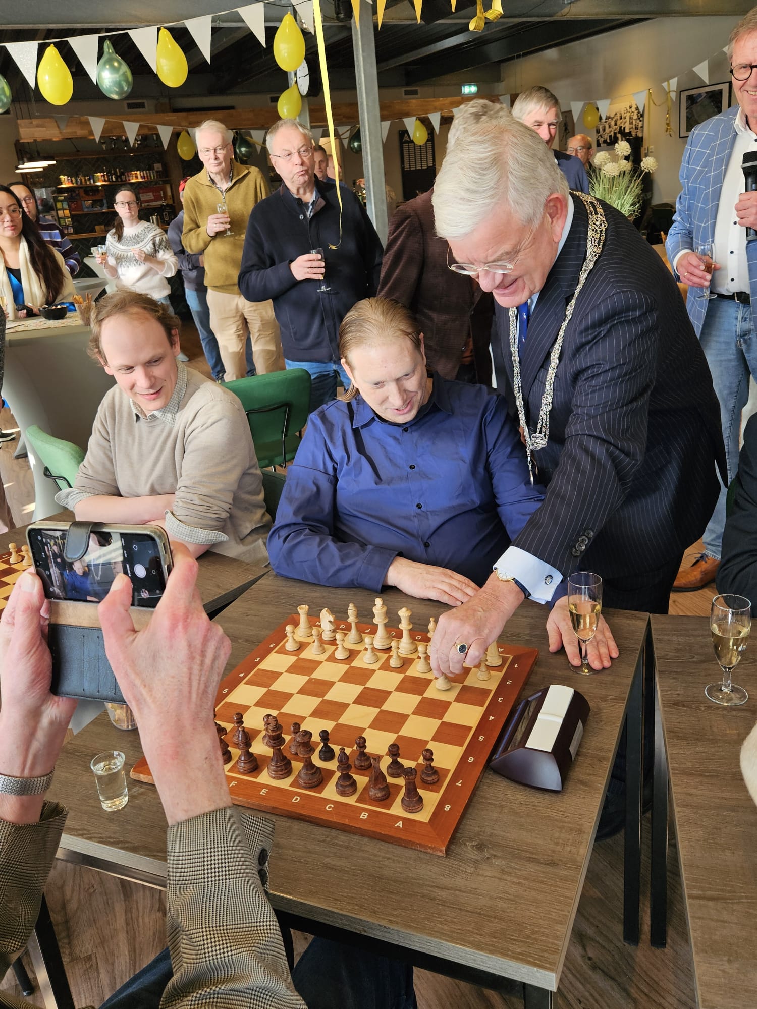 Burgemeester Jan van Zanen verricht de openingszet tijdens het 100-jarig jubileum van de Haagse Schaak Vereniging